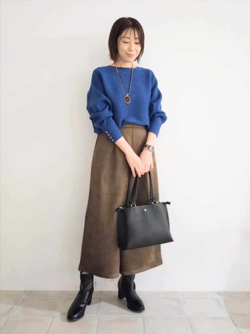 ベージュ系のブルゾン、ブルー系のニット/セーター、ブラウン系のその他パンツを着用したレディースの秋コーディネートの6枚目の写真