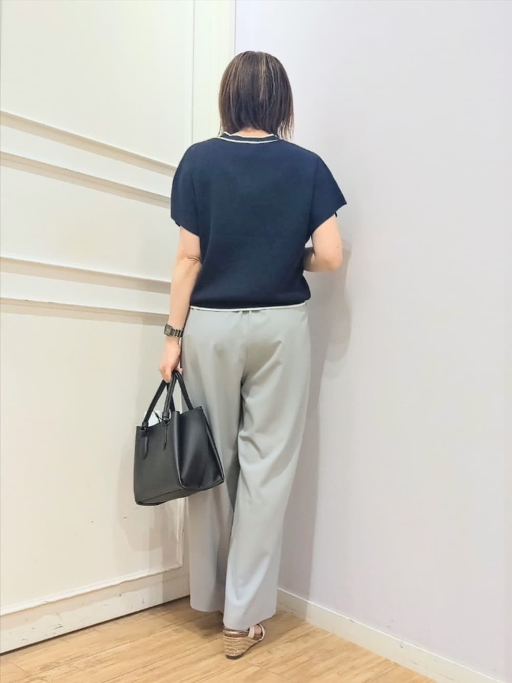 ブルー系のニット/セーター、グレー系のその他パンツ、ブラック系のトートバッグを着用したレディースの春コーディネートの4枚目の写真
