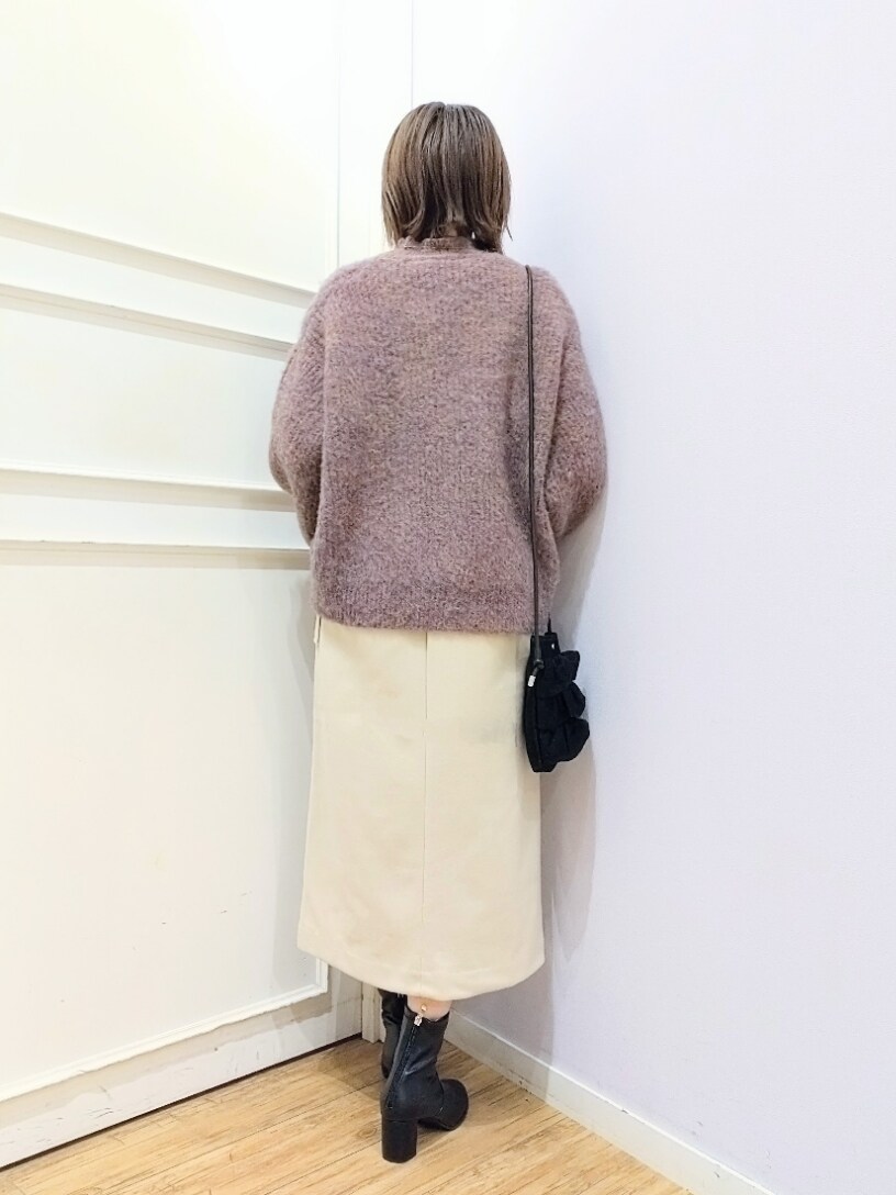 ピンク系のニット/セーター、ブラック系のショルダーバッグ、ベージュ系のスカートを着用したレディースの冬コーディネートの3枚目の写真