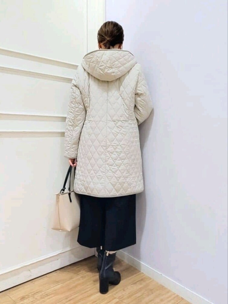 ベージュ系のその他アウター、ブラック系のニット/セーター、ブラック系のその他パンツを着用したレディースの冬コーディネートの3枚目の写真