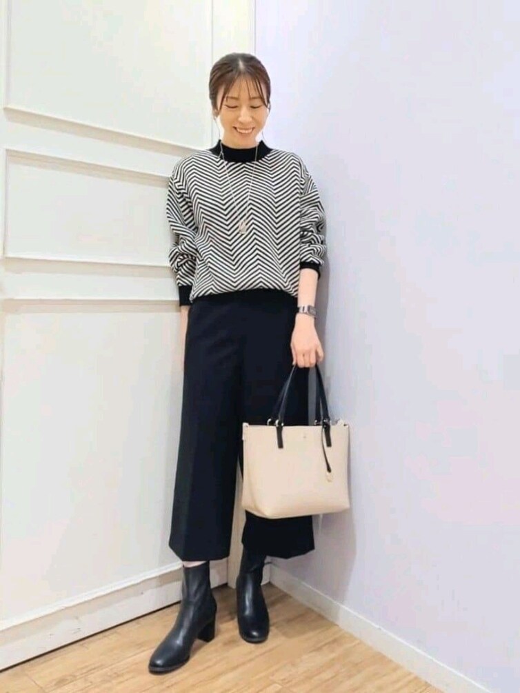 ベージュ系のその他アウター、ブラック系のニット/セーター、ブラック系のその他パンツを着用したレディースの冬コーディネートの4枚目の写真