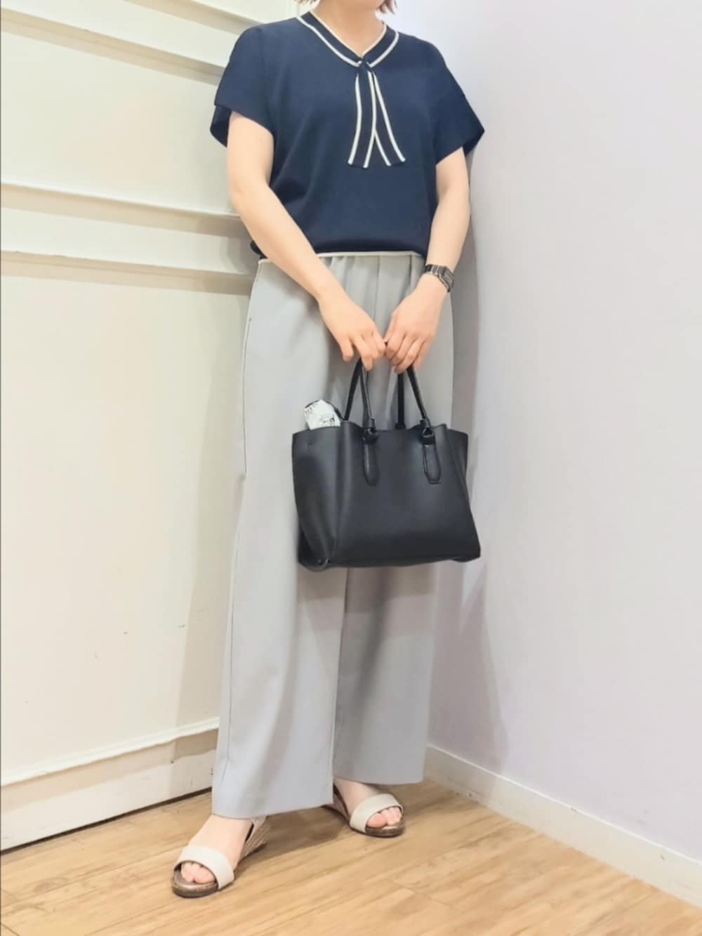ブルー系のニット/セーター、グレー系のその他パンツ、ブラック系のトートバッグを着用したレディースの春コーディネートの5枚目の写真