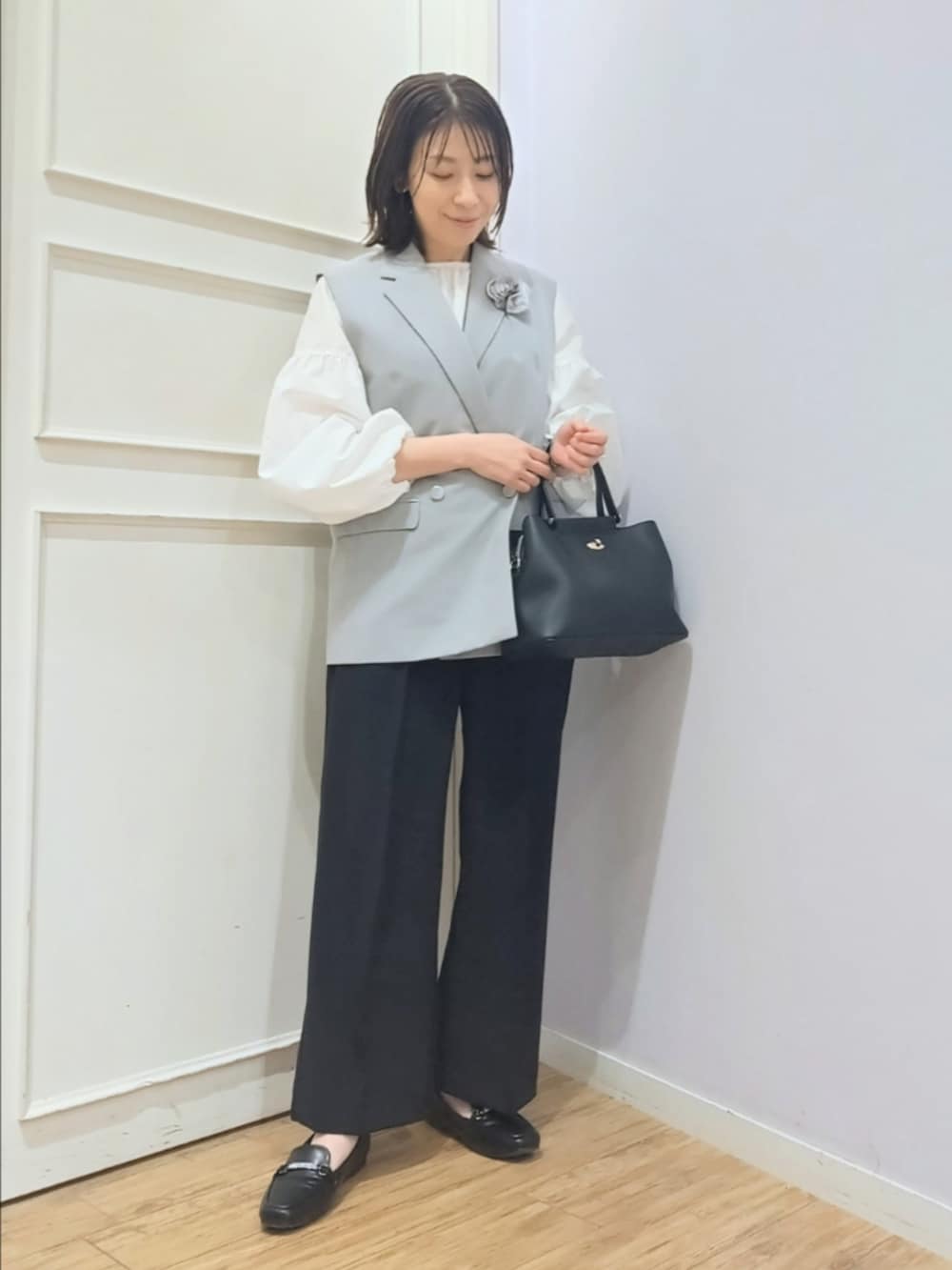 グレー系のベスト、ホワイト系のシャツ/ブラウス、ブラック系のその他パンツを着用したレディースの冬コーディネートの5枚目の写真