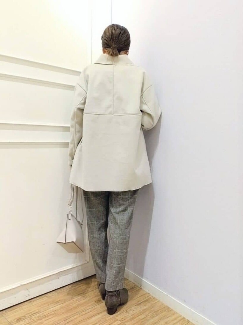 ホワイト系のチェスターコート、ピンク系のニット/セーター、ベージュ系のその他パンツを着用したレディースの冬コーディネートの3枚目の写真