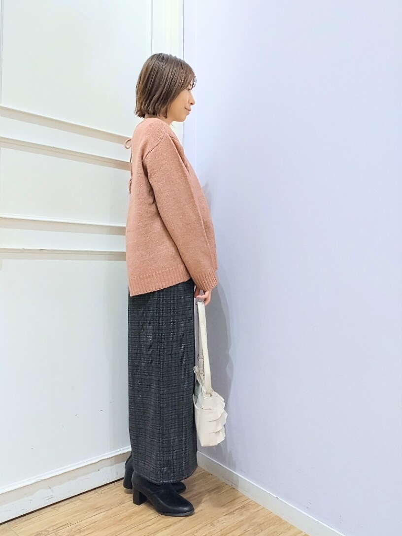 ピンク系のニット/セーター、ホワイト系のショルダーバッグ、ブラック系のブーツを着用したレディースの冬コーディネートの2枚目の写真