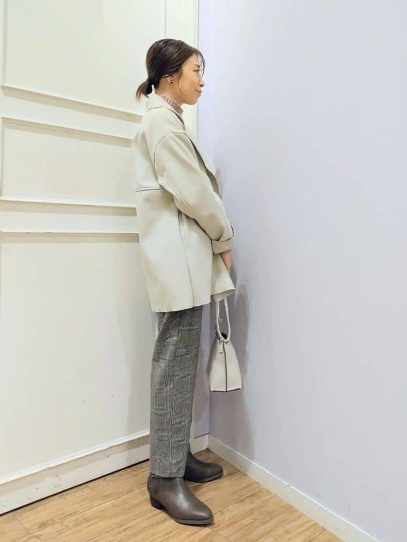 ホワイト系のチェスターコート、ピンク系のニット/セーター、ベージュ系のその他パンツを着用したレディースの冬コーディネートの2枚目の写真