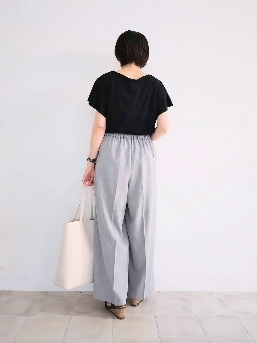 ブラック系のTシャツ/カットソー、グレー系のその他パンツ、ホワイト系のトートバッグを着用したレディースの夏コーディネートの3枚目の写真