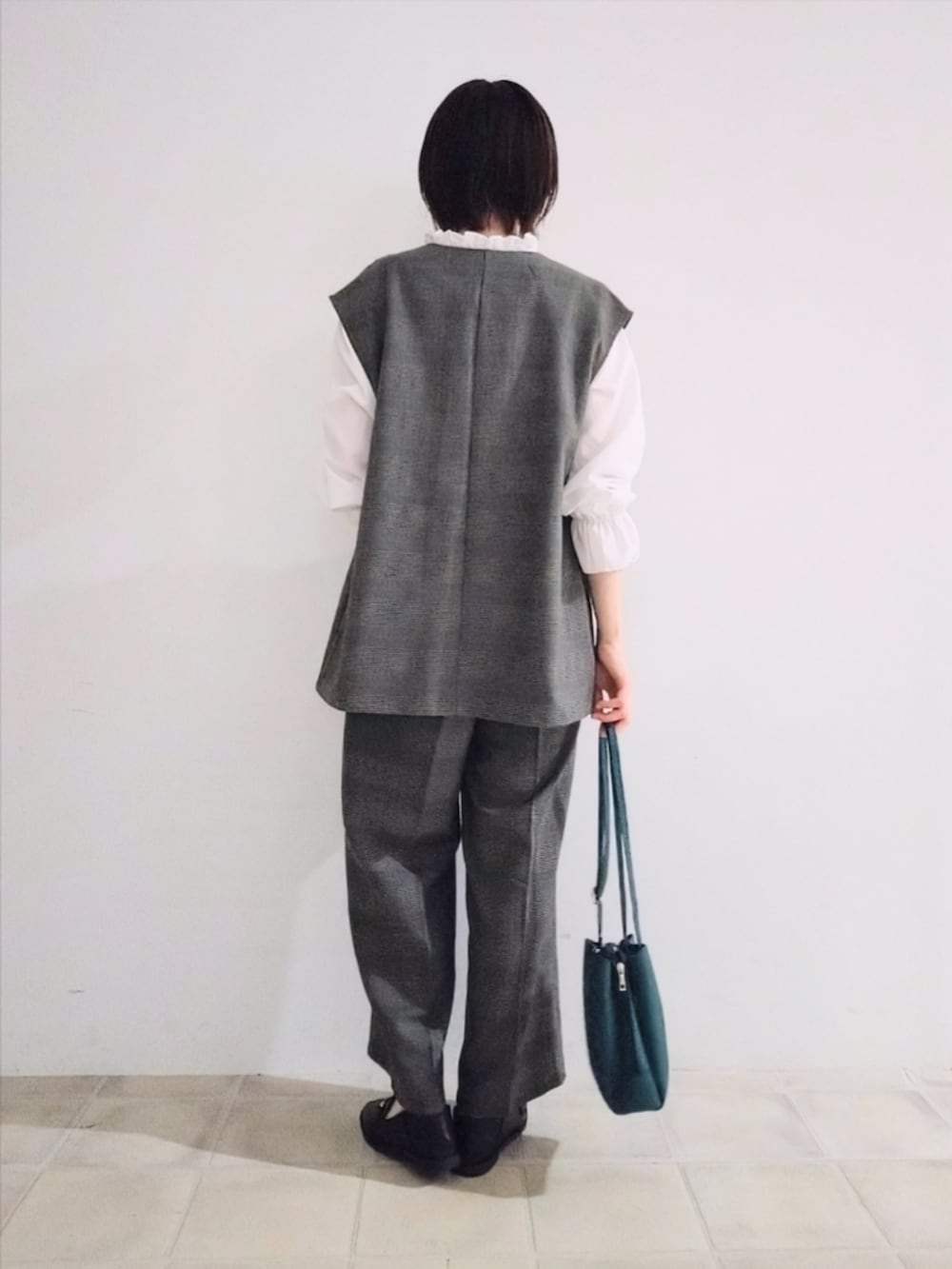 グレー系のベスト、ホワイト系のシャツ/ブラウス、グレー系のその他パンツを着用したレディースの秋コーディネートの3枚目の写真