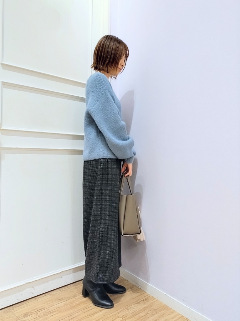 ブルー系のニット/セーター、グレー系のその他パンツ、ブラウン系のトートバッグを着用したレディースの冬コーディネートの2枚目の写真