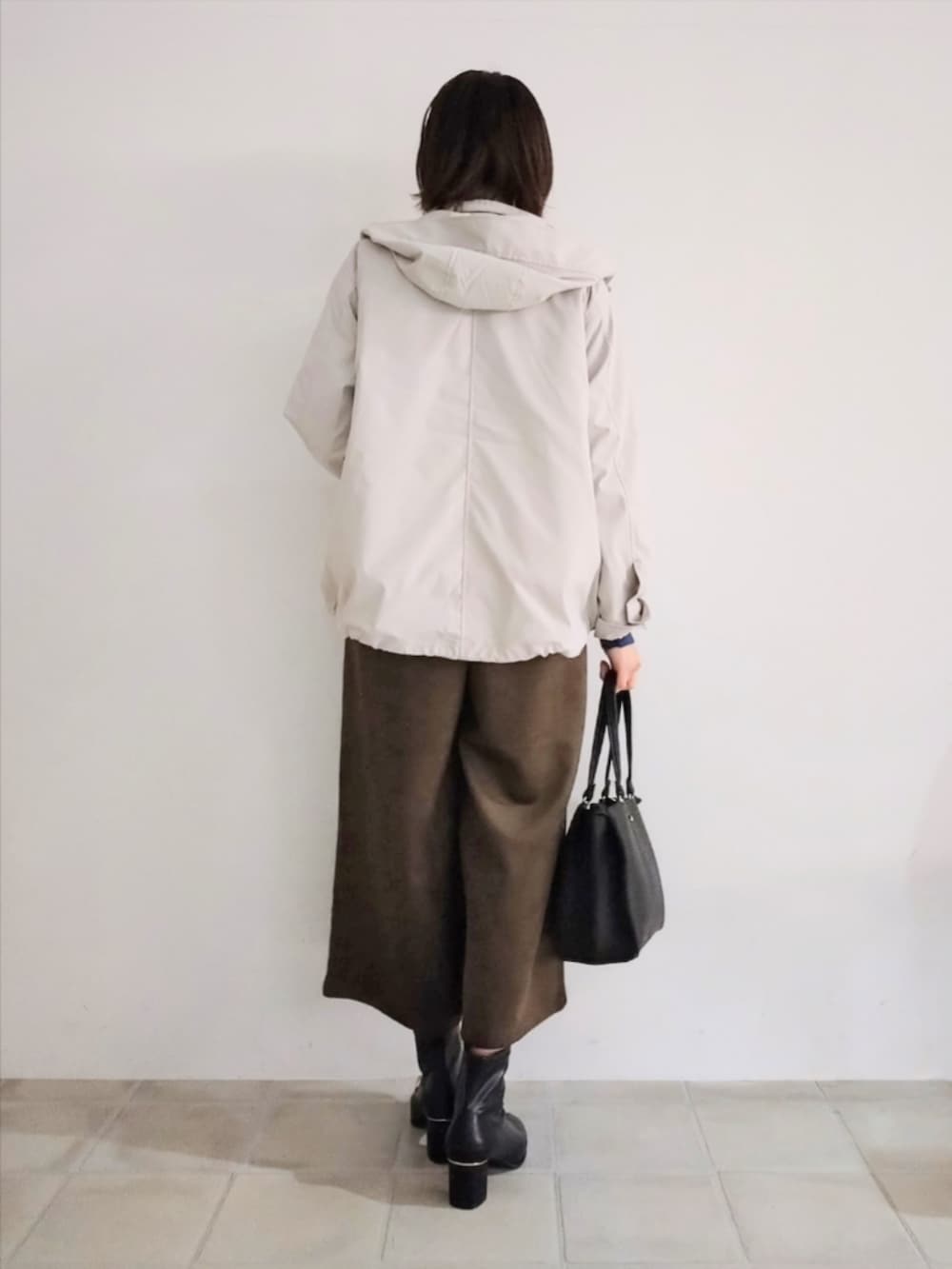 ベージュ系のブルゾン、ブルー系のニット/セーター、ブラウン系のその他パンツを着用したレディースの秋コーディネートの4枚目の写真