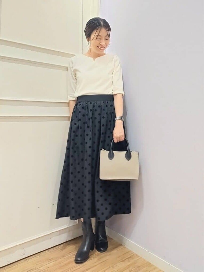 パープル系のカーディガン/ボレロ、ホワイト系のTシャツ/カットソー、グレー系のスカートを着用したレディースの冬コーディネートの4枚目の写真