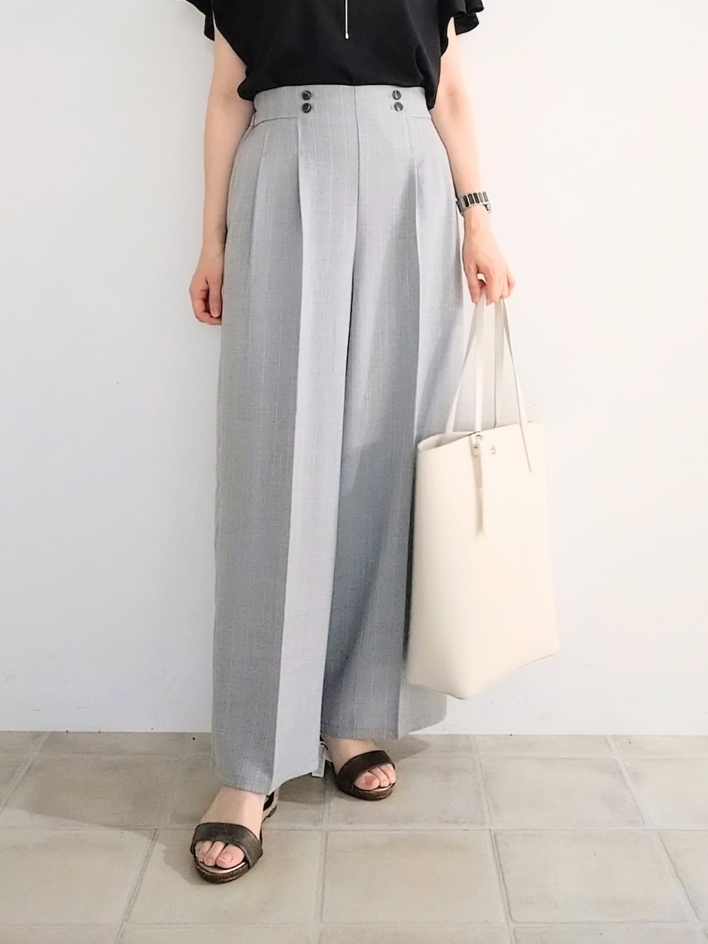 ブラック系のTシャツ/カットソー、グレー系のその他パンツ、ホワイト系のトートバッグを着用したレディースの夏コーディネートの5枚目の写真