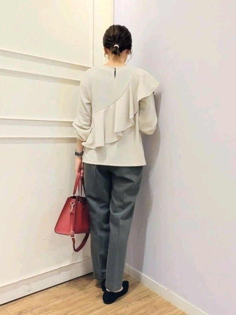 ベージュ系のTシャツ/カットソー、グレー系のその他パンツ、レッド系のトートバッグを着用したレディースの冬コーディネートの3枚目の写真