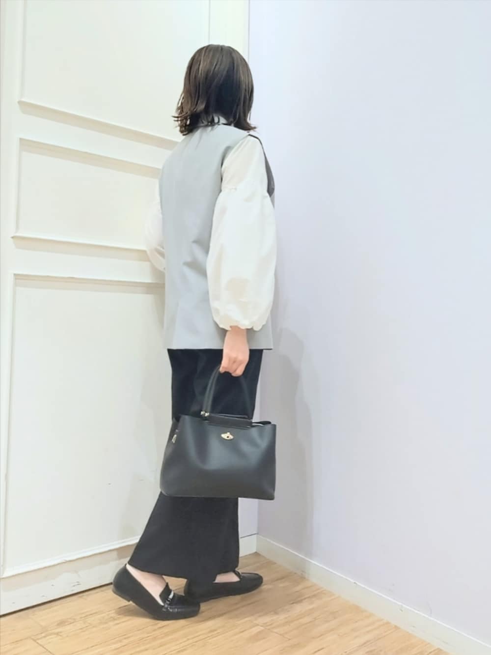 グレー系のベスト、ホワイト系のシャツ/ブラウス、ブラック系のその他パンツを着用したレディースの冬コーディネートの3枚目の写真