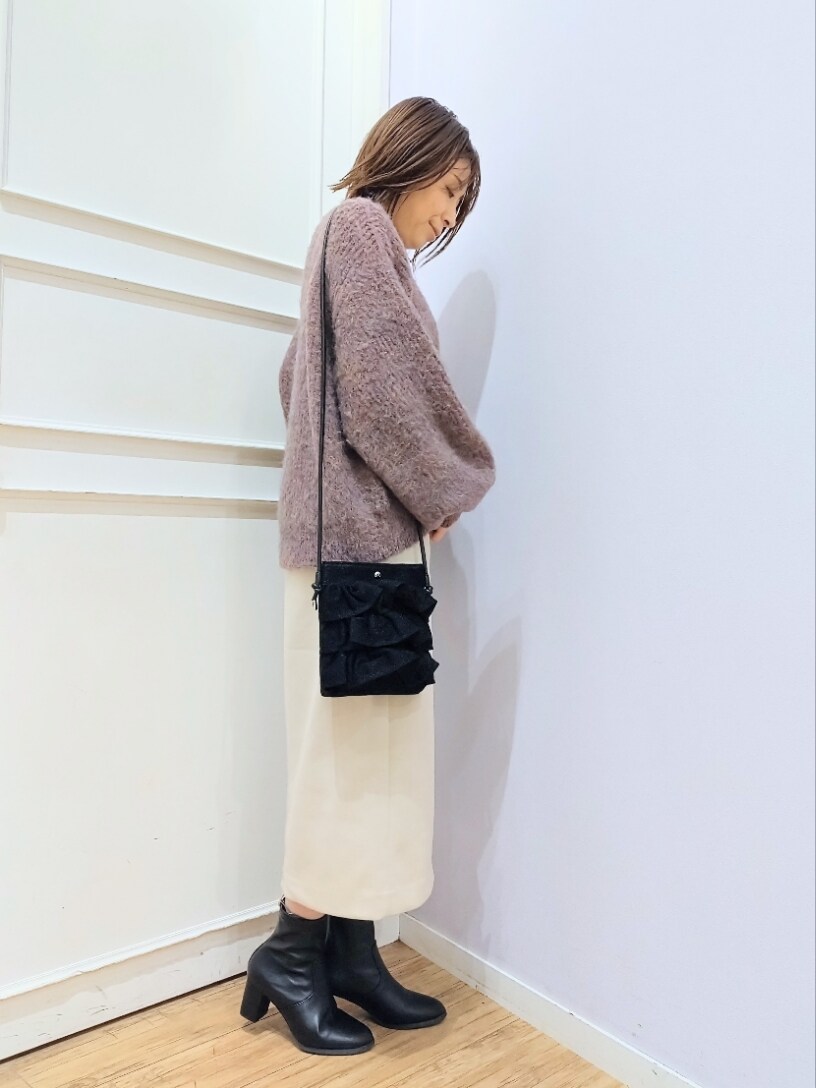 ピンク系のニット/セーター、ブラック系のショルダーバッグ、ベージュ系のスカートを着用したレディースの冬コーディネートの2枚目の写真