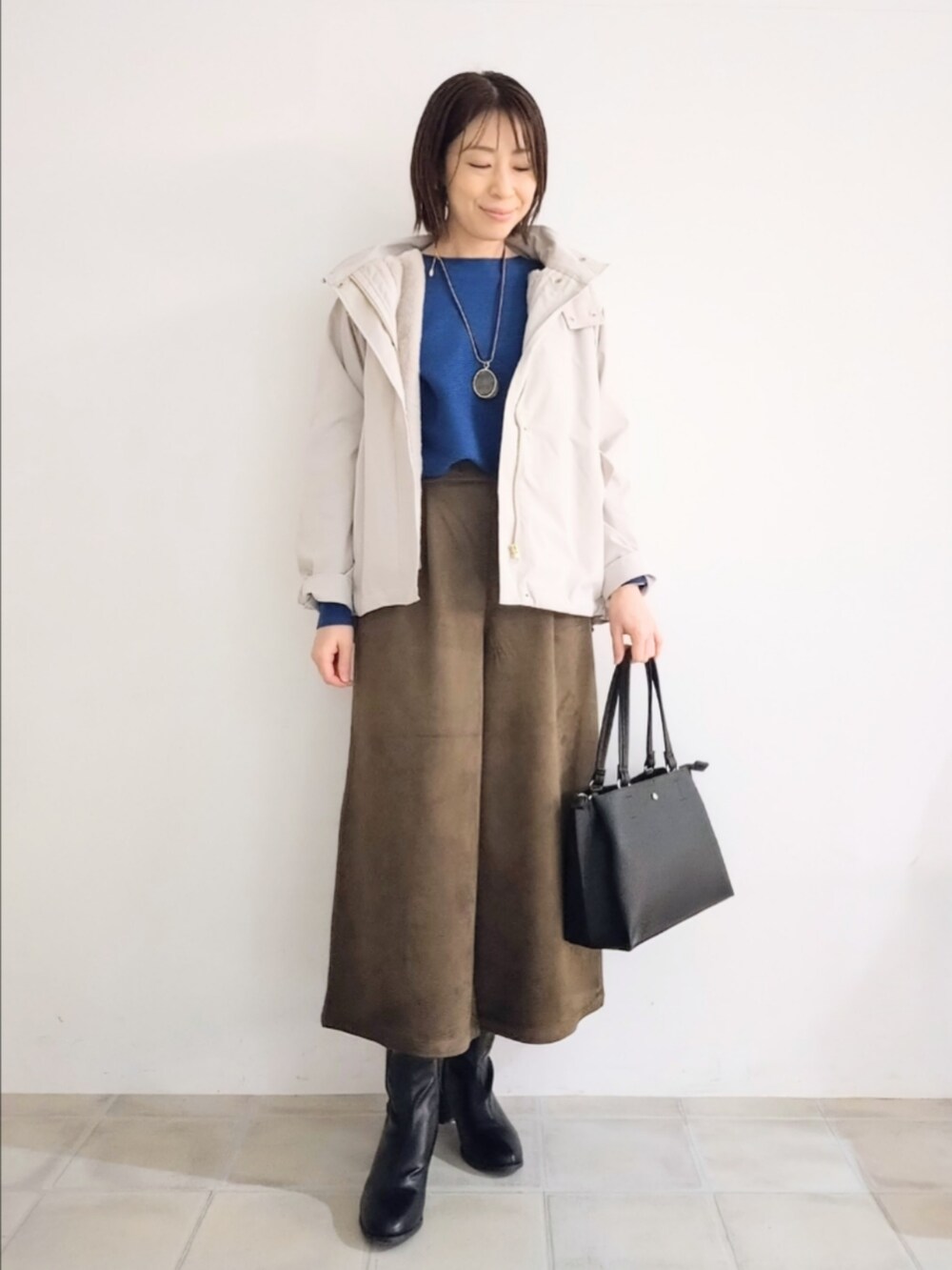 ベージュ系のブルゾン、ブルー系のニット/セーター、ブラウン系のその他パンツを着用したレディースの秋コーディネートの5枚目の写真