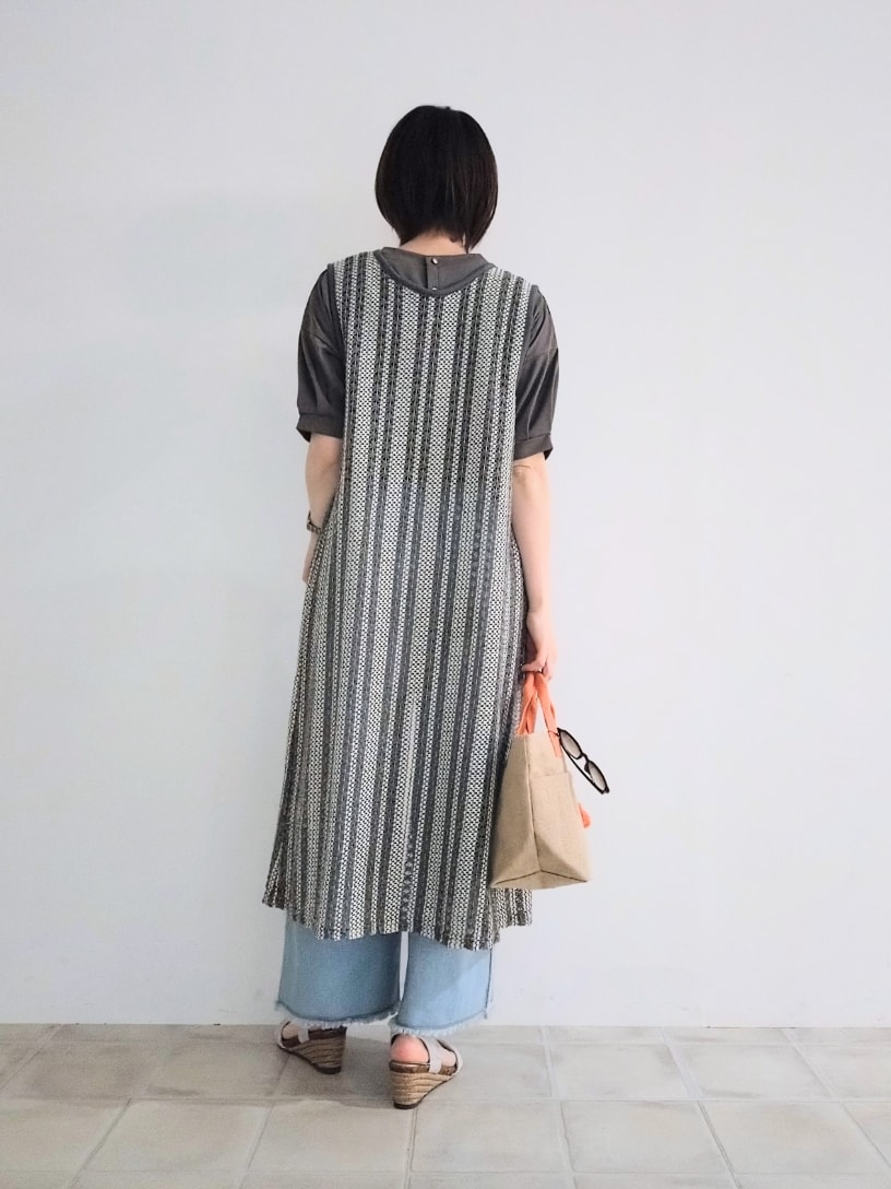 グレー系のTシャツ/カットソー、グレー系のベスト、ブルー系のデニムパンツを着用したレディースの春コーディネートの3枚目の写真