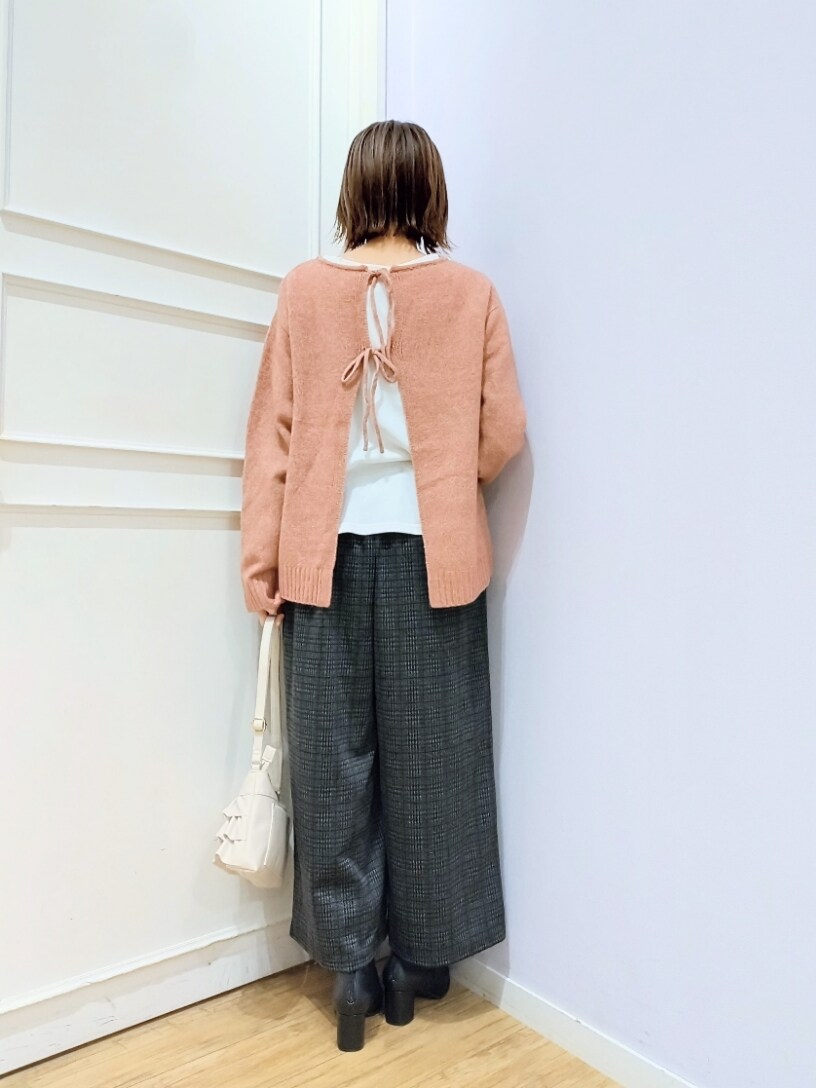 ピンク系のニット/セーター、ホワイト系のショルダーバッグ、ブラック系のブーツを着用したレディースの冬コーディネートの3枚目の写真