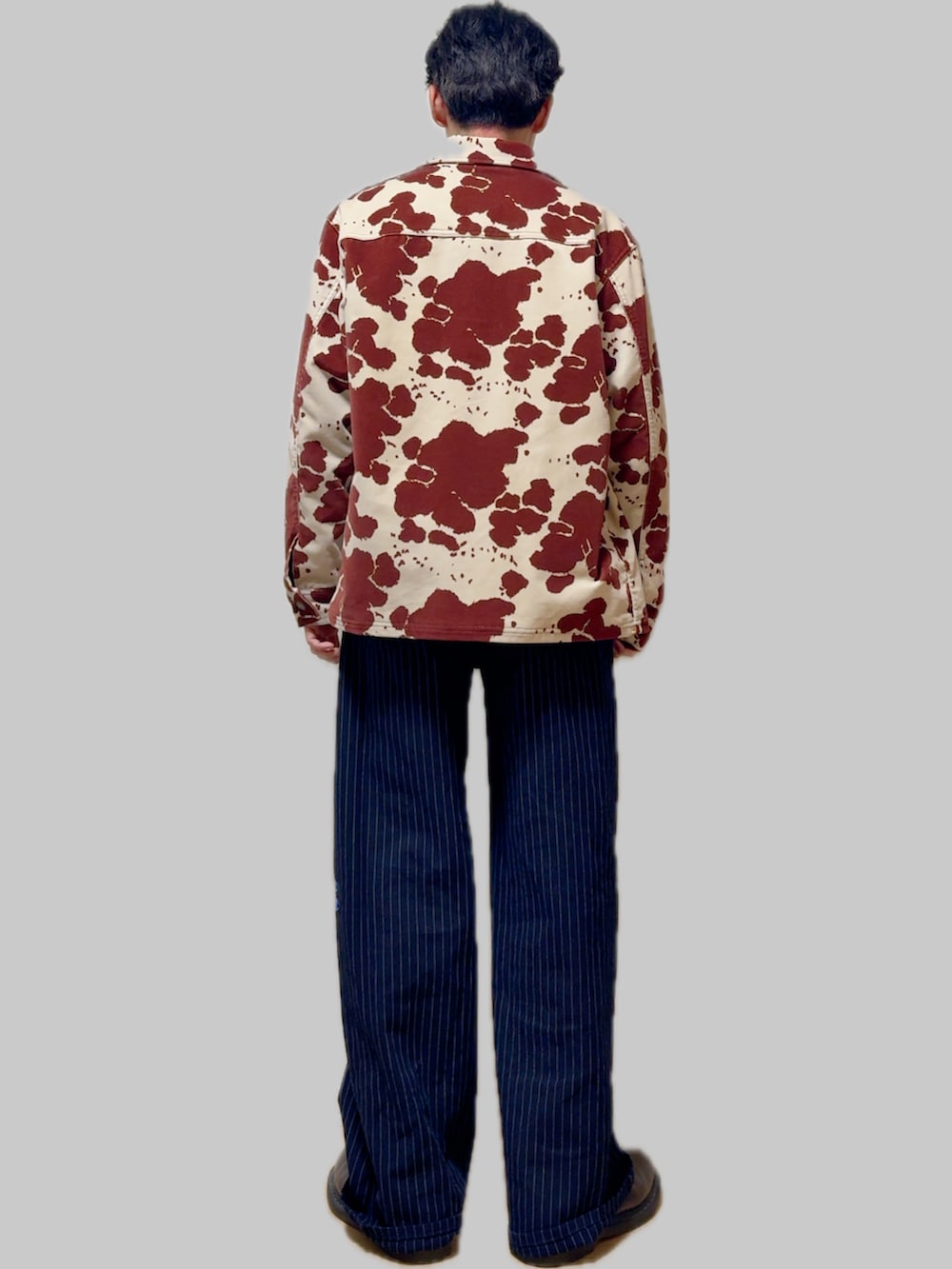 その他のデニムパンツ、ブラウン系のドレスシューズ、ブラウン系のカバーオールを着用したメンズの冬コーディネートの3枚目の写真