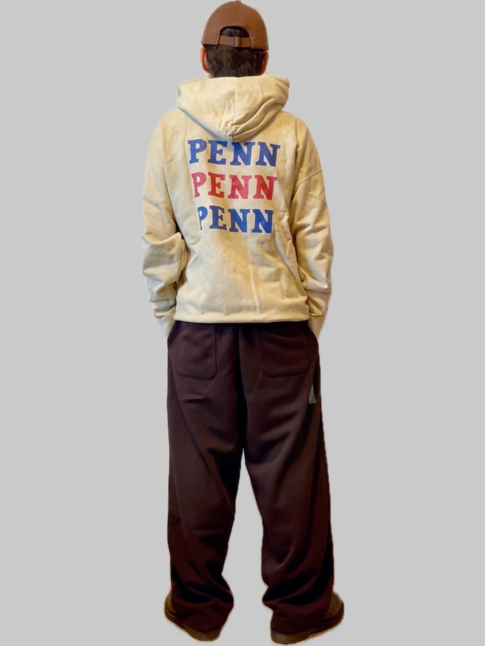 ベージュ系のパーカー、ブラック系のスウェットパンツ、ブラウン系のドレスシューズを着用したメンズの秋コーディネートの2枚目の写真