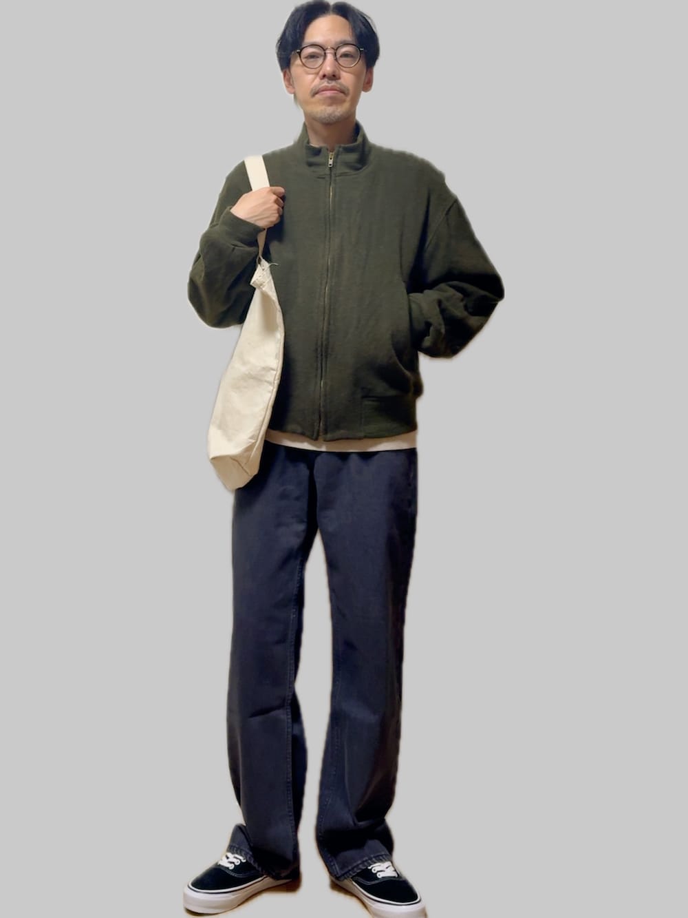 ベージュ系のニット/セーター、グリーン系のミリタリージャケット、ブルー系のデニムパンツを着用したメンズの冬コーディネートの4枚目の写真