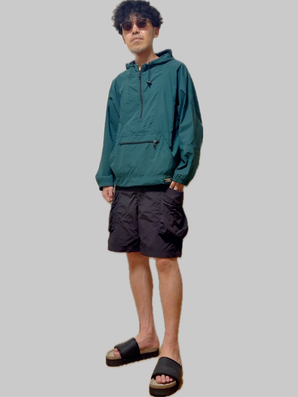 ブラック系のサンダル、ブラック系のカーゴパンツ、グリーン系のマウンテンパーカーを着用したメンズの夏コーディネートの3枚目の写真