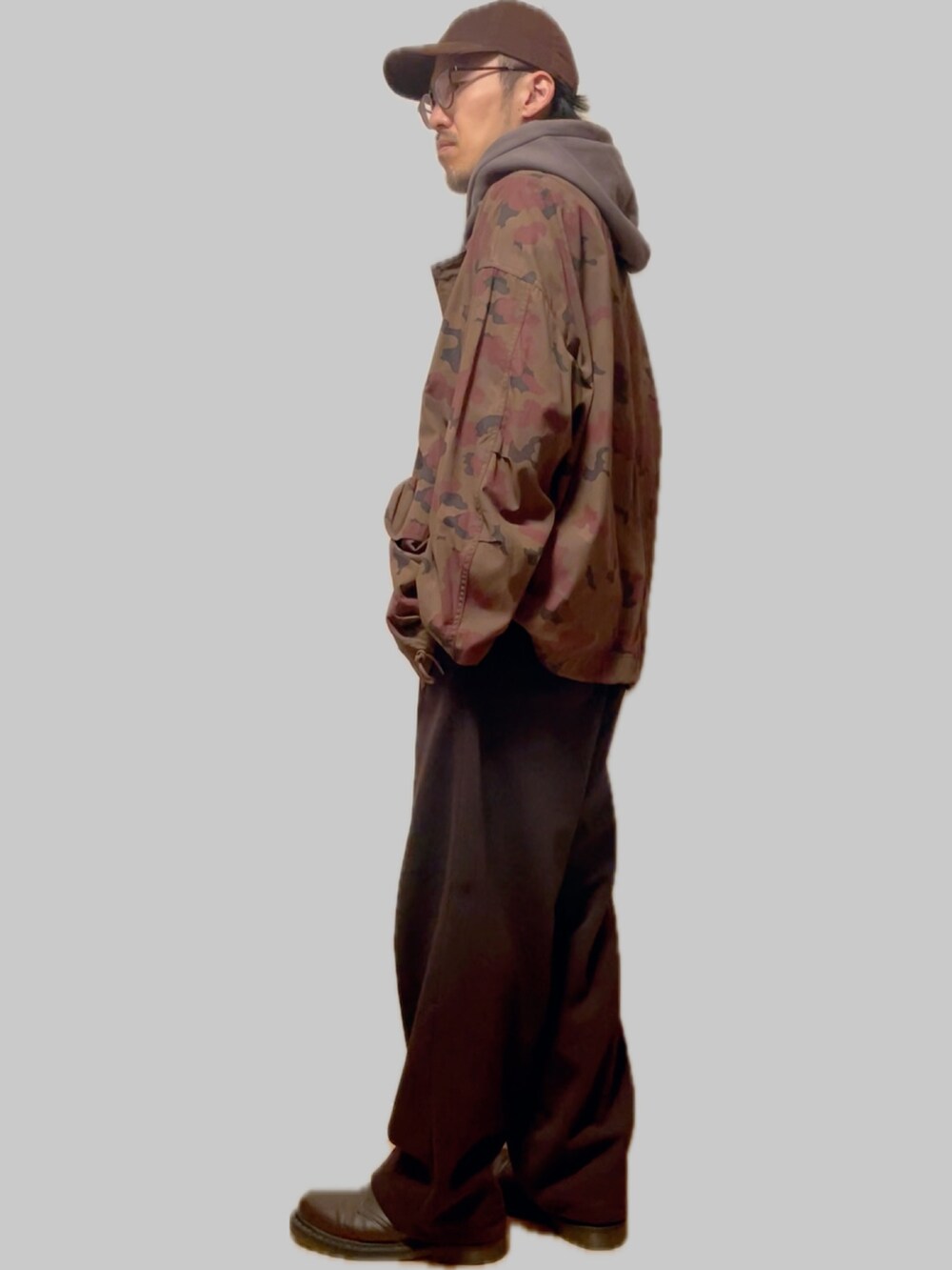 グレー系のパーカー、ブラウン系のミリタリージャケット、ブラック系のスウェットパンツを着用したメンズの冬コーディネートの2枚目の写真