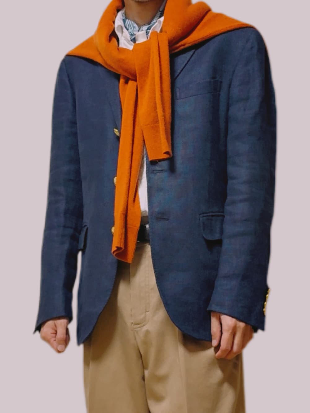 オレンジ系のニット/セーター、ブルー系のテーラードジャケット、ベージュ系のチノパンツを着用したメンズの冬コーディネートの5枚目の写真