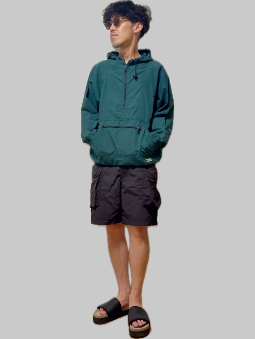 ブラック系のサンダル、ブラック系のカーゴパンツ、グリーン系のマウンテンパーカーを着用したメンズの夏コーディネートの4枚目の写真