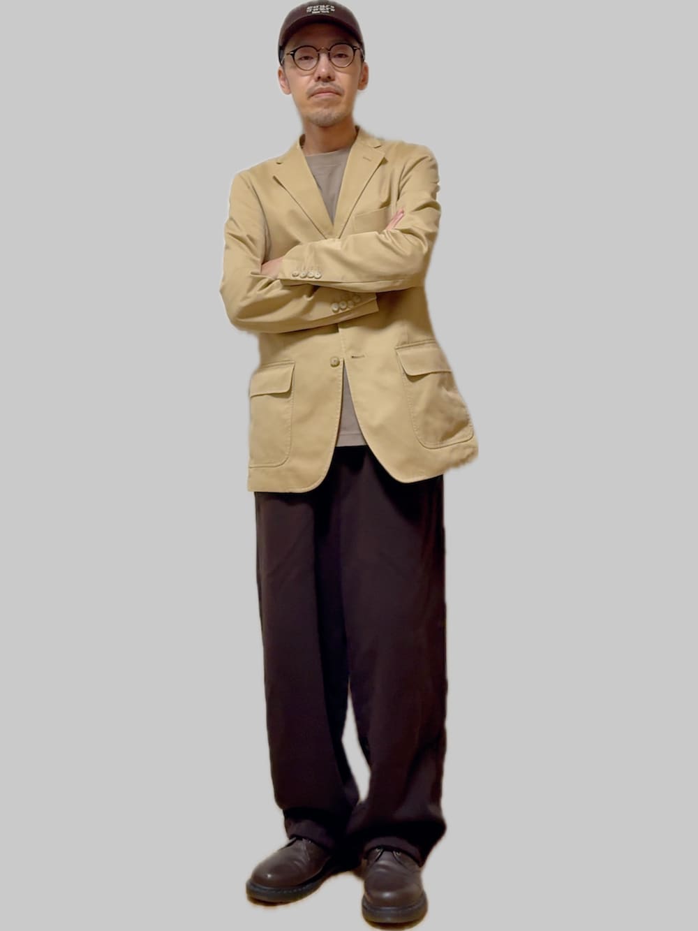 ブラック系のスウェットパンツ、ブラウン系のドレスシューズ、ベージュ系のテーラードジャケットを着用したメンズの秋コーディネートの2枚目の写真