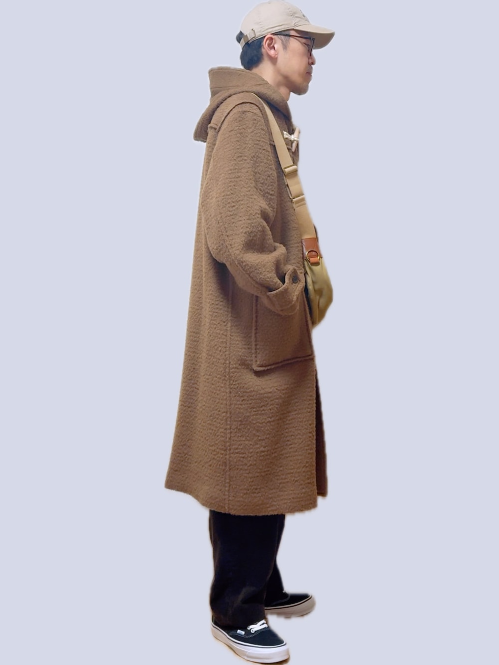 ベージュ系のショルダーバッグ、ベージュ系のダッフルコート、ブラウン系のその他パンツを着用したメンズの春コーディネートの4枚目の写真