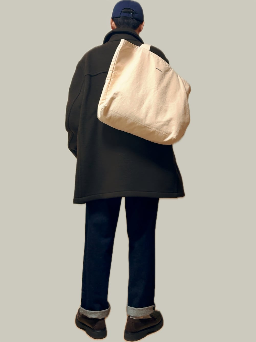 グリーン系のステンカラーコート、ホワイト系のシャツ/ブラウス、オレンジ系のニット/セーターを着用したメンズの冬コーディネートの3枚目の写真