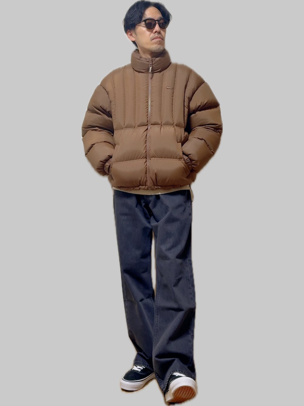 ブラック系のスニーカー、イエロー系のダウンジャケット/コート、ブルー系のデニムパンツを着用したメンズの冬コーディネートの4枚目の写真