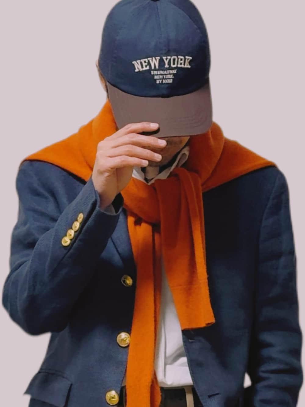 オレンジ系のニット/セーター、ブルー系のテーラードジャケット、ベージュ系のチノパンツを着用したメンズの冬コーディネートの3枚目の写真