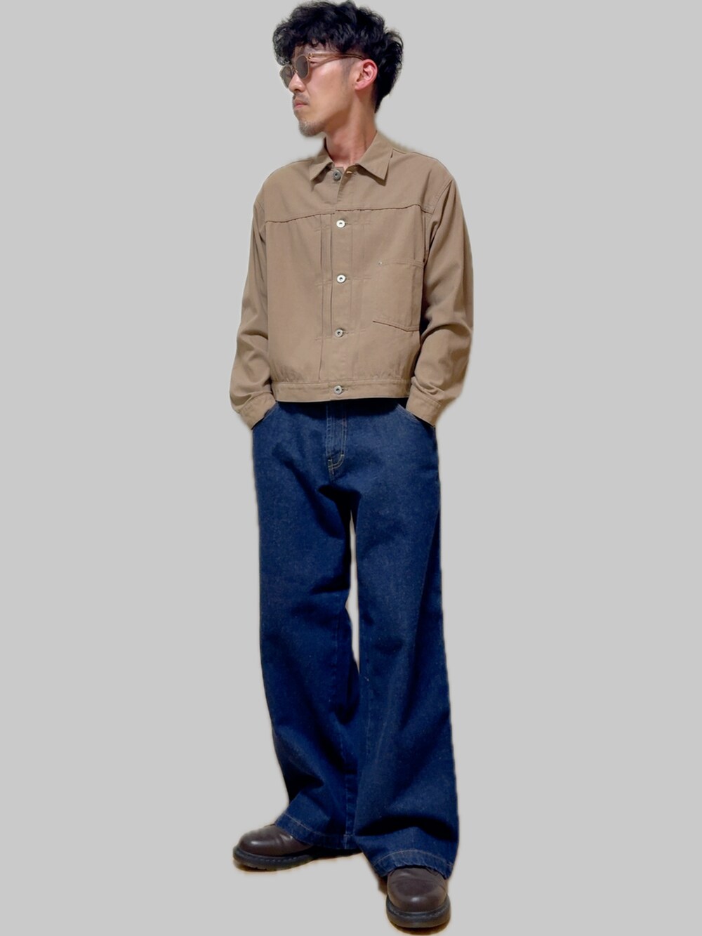 ベージュ系のデニムジャケット、ブルー系のデニムパンツ、ブラウン系のドレスシューズを着用したメンズの夏コーディネートの2枚目の写真