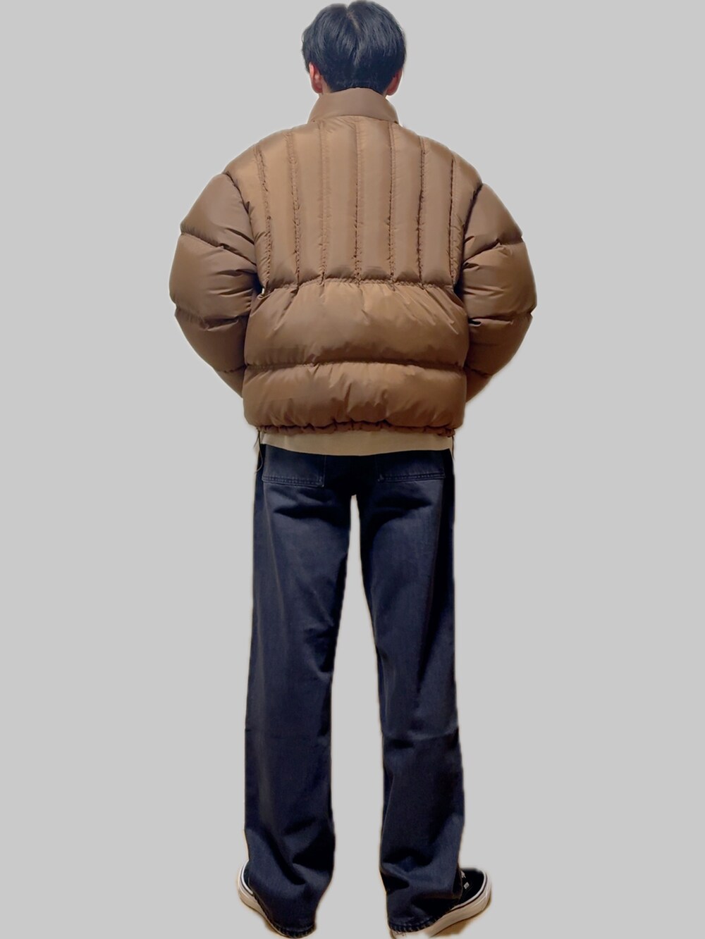 ブラック系のスニーカー、イエロー系のダウンジャケット/コート、ブルー系のデニムパンツを着用したメンズの冬コーディネートの3枚目の写真