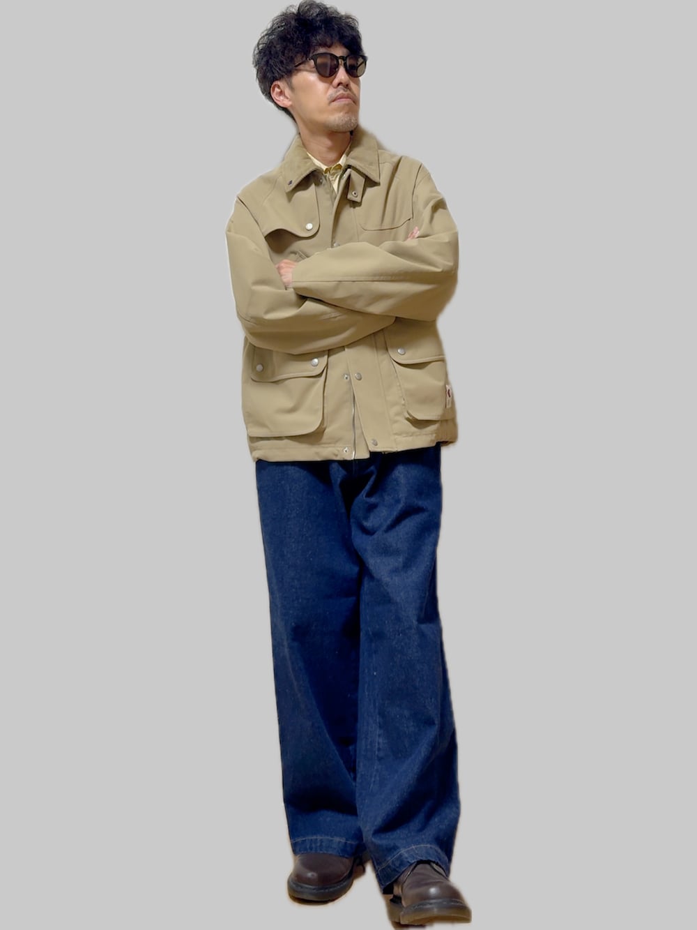 ブラウン系のドレスシューズ、イエロー系のシャツ/ブラウス、ベージュ系のナイロンジャケットを着用したメンズの秋コーディネートの3枚目の写真