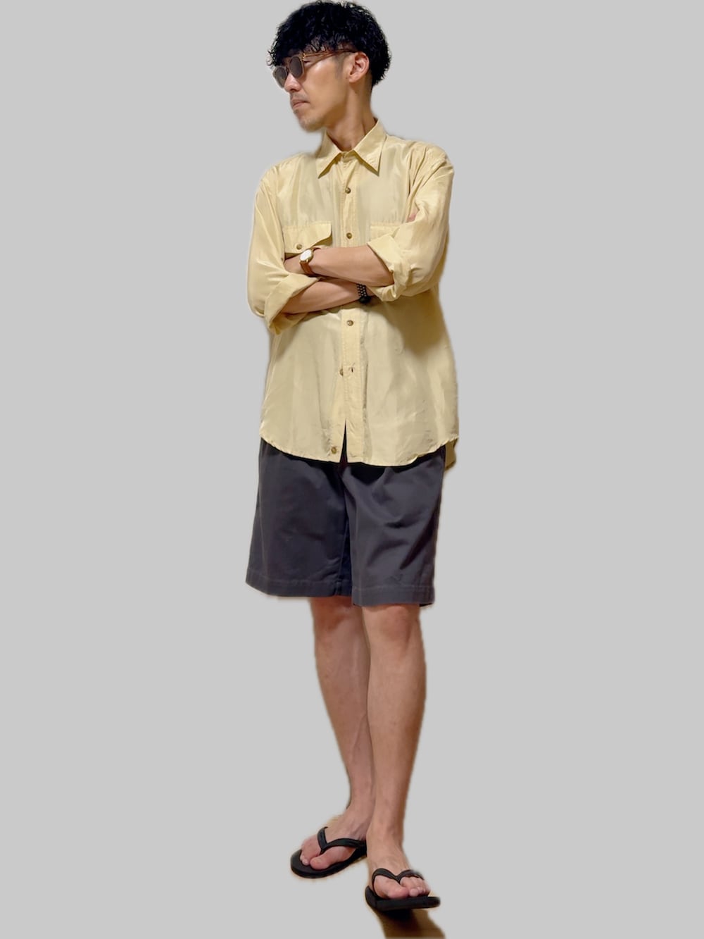 イエロー系のシャツ/ブラウス、グレー系のチノパンツ、ブラック系のサンダルを着用したメンズの夏コーディネートの3枚目の写真