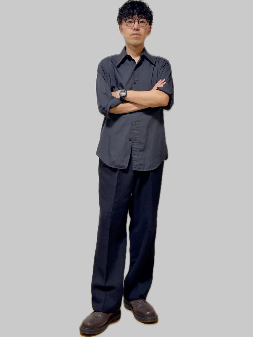 ブラック系のスラックス、ブラウン系のドレスシューズ、ブラック系のシャツ/ブラウスを着用したメンズの夏コーディネートの3枚目の写真