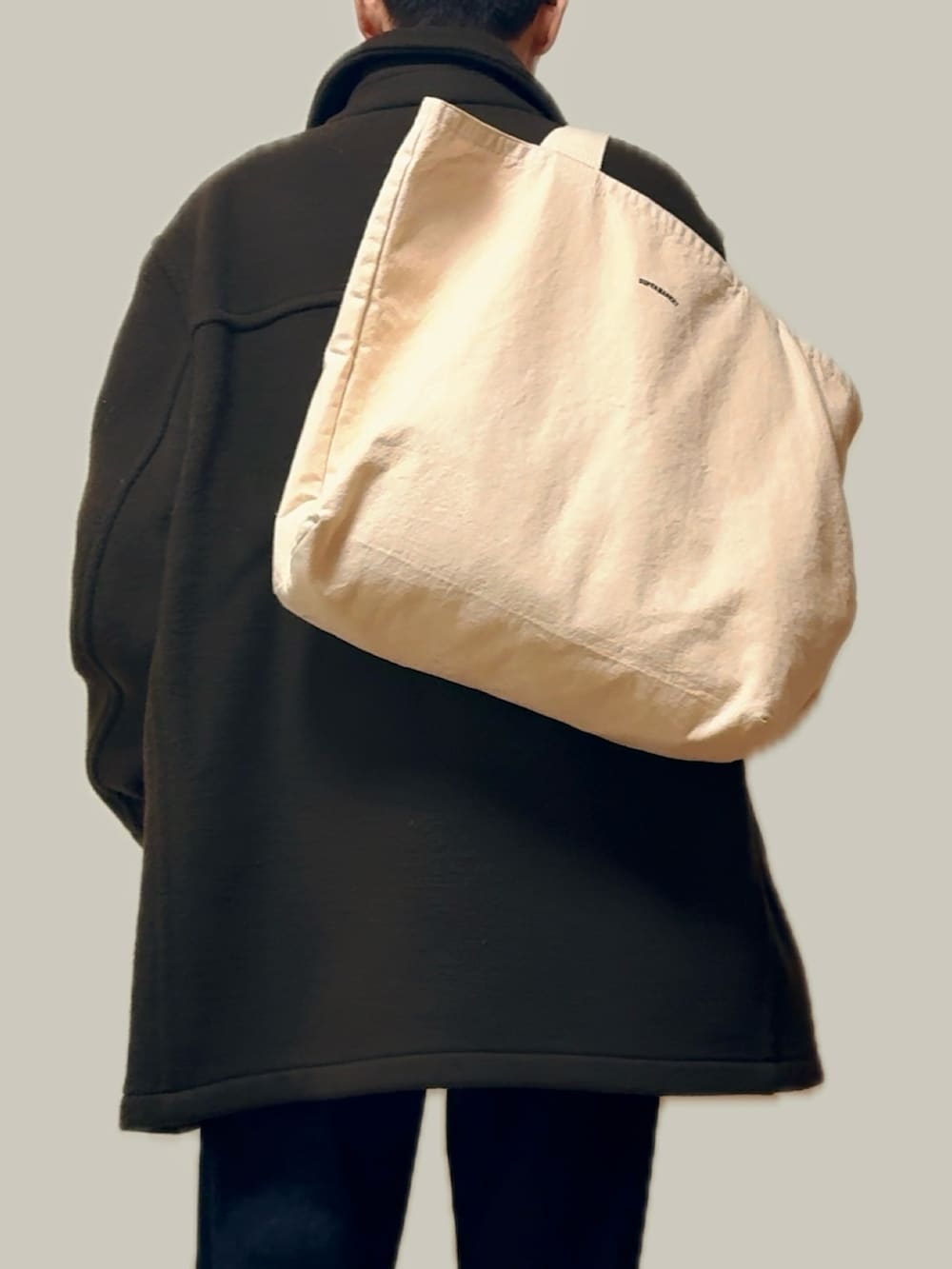 グリーン系のステンカラーコート、ホワイト系のシャツ/ブラウス、オレンジ系のニット/セーターを着用したメンズの冬コーディネートの4枚目の写真