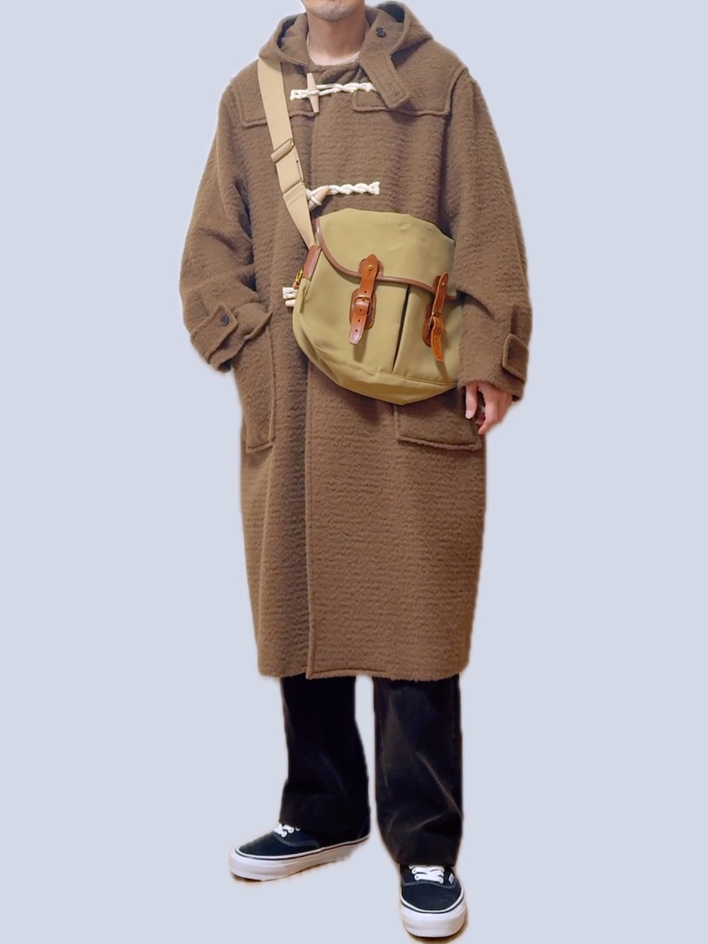 ベージュ系のショルダーバッグ、ベージュ系のダッフルコート、ブラウン系のその他パンツを着用したメンズの春コーディネートの3枚目の写真