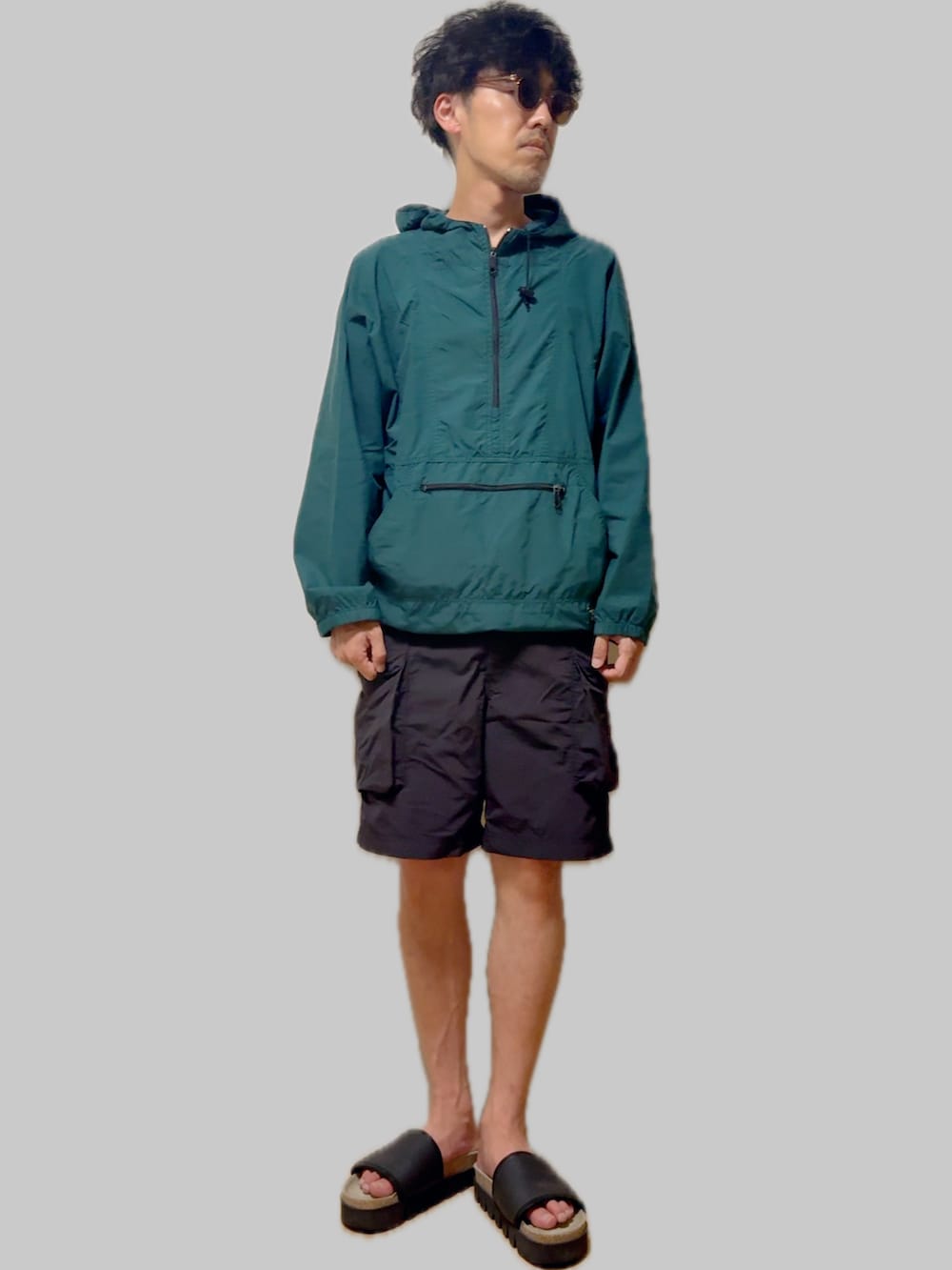 ブラック系のサンダル、ブラック系のカーゴパンツ、グリーン系のマウンテンパーカーを着用したメンズの夏コーディネートの2枚目の写真