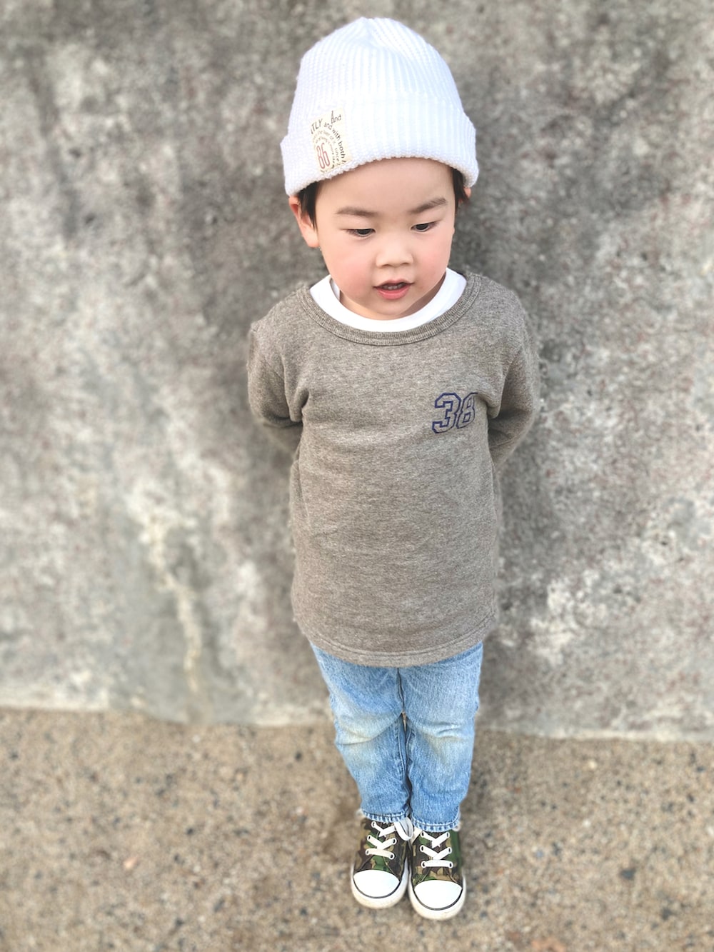 ブラウン系のスウェット、ブルー系のデニムパンツ、グリーン系のスニーカーを着用したキッズの冬コーディネートの2枚目の写真