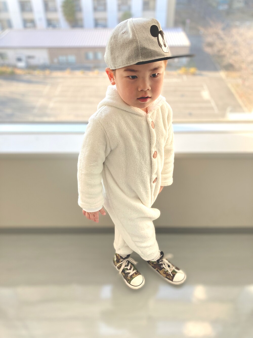 ホワイト系のつなぎ/オールインワン、グリーン系のスニーカー、グレー系のキャップを着用したキッズの春コーディネートの3枚目の写真