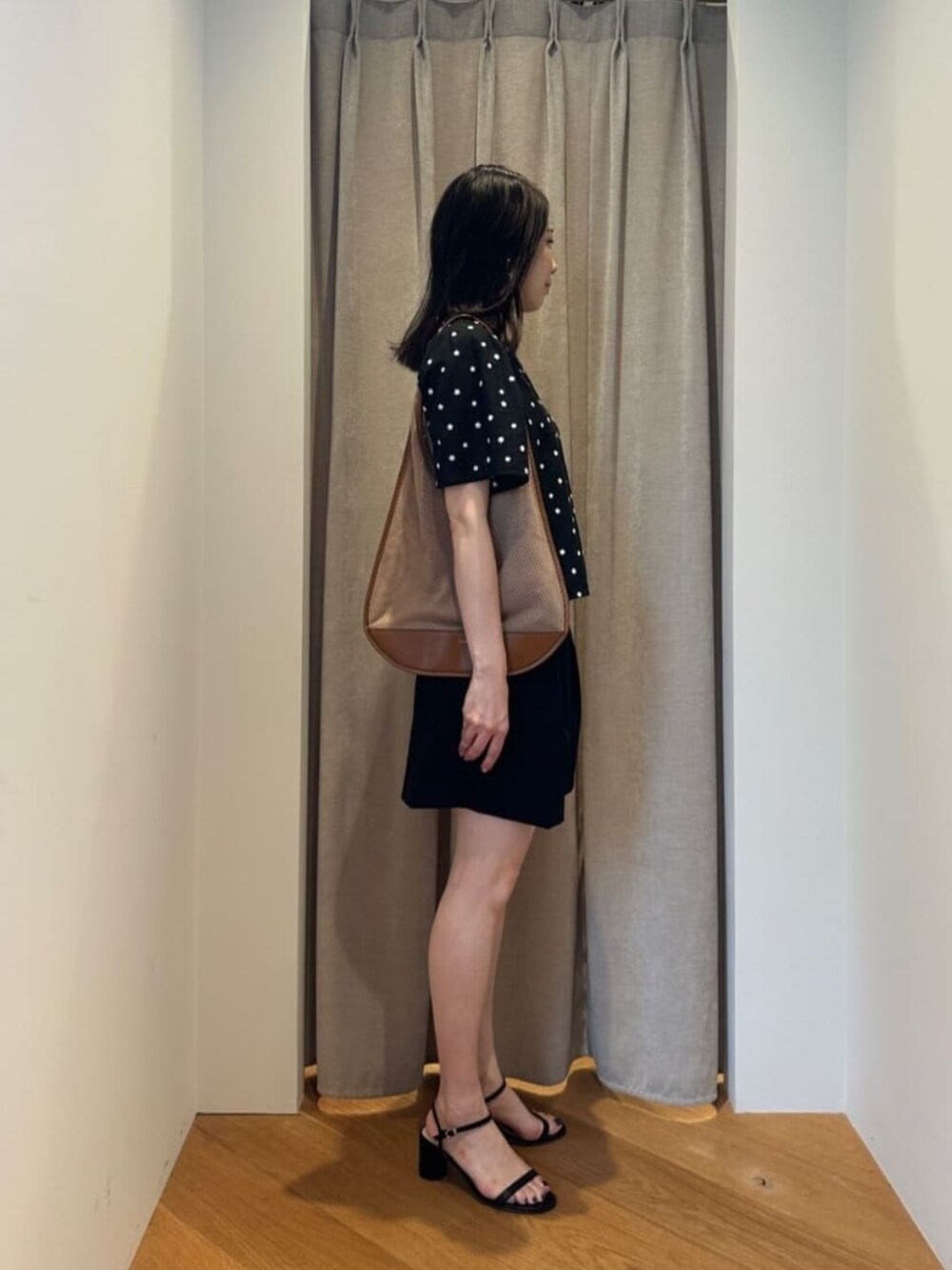 ブラック系のサンダル、ベージュ系のショルダーバッグ、ブラック系のシャツ/ブラウスを着用したレディースの夏コーディネートの3枚目の写真