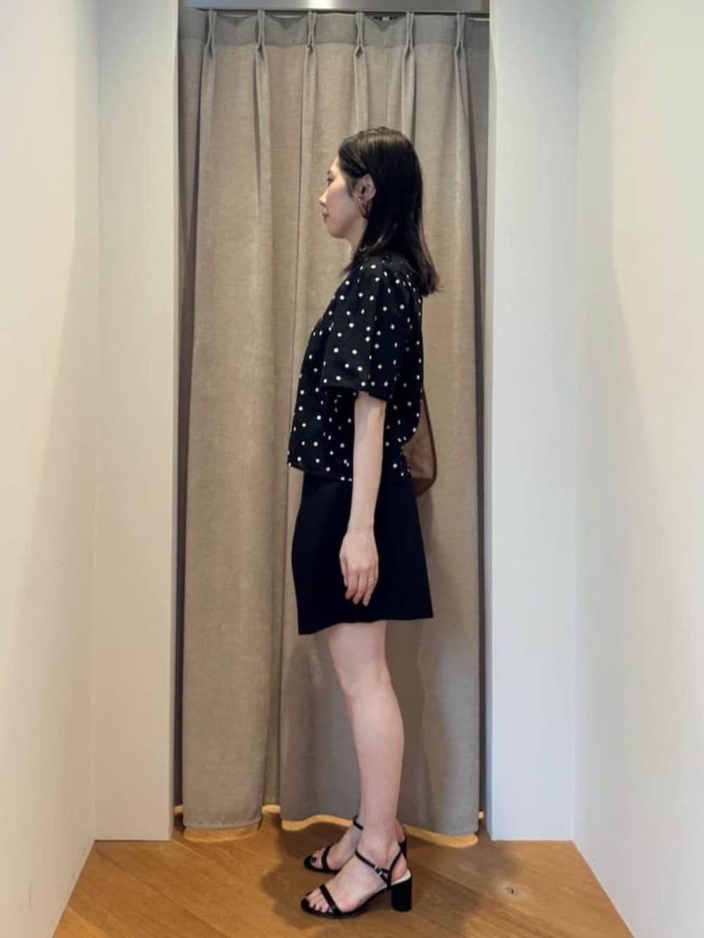 ブラック系のサンダル、ベージュ系のショルダーバッグ、ブラック系のシャツ/ブラウスを着用したレディースの夏コーディネートの2枚目の写真