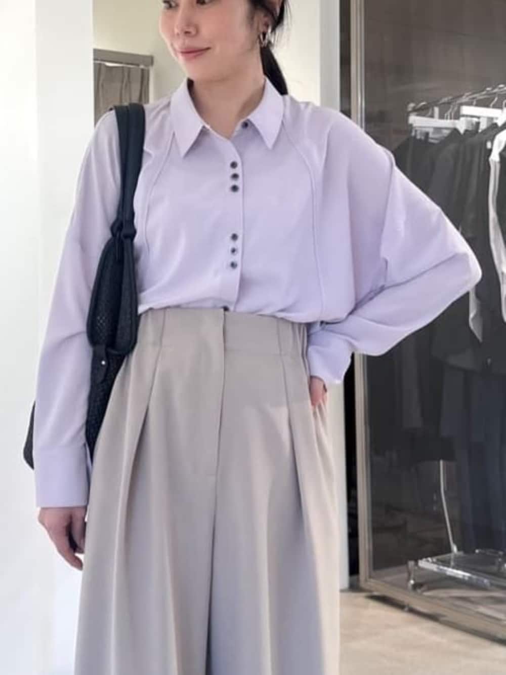 パープル系のシャツ/ブラウス、ベージュ系のスラックス、ブラック系のショルダーバッグを着用したレディースの冬コーディネートの2枚目の写真