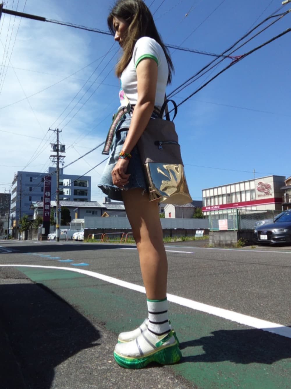 ブルー系のデニムスカート、ホワイト系のTシャツ/カットソー、グリーン系のサンダルを着用したレディースの夏コーディネートの2枚目の写真