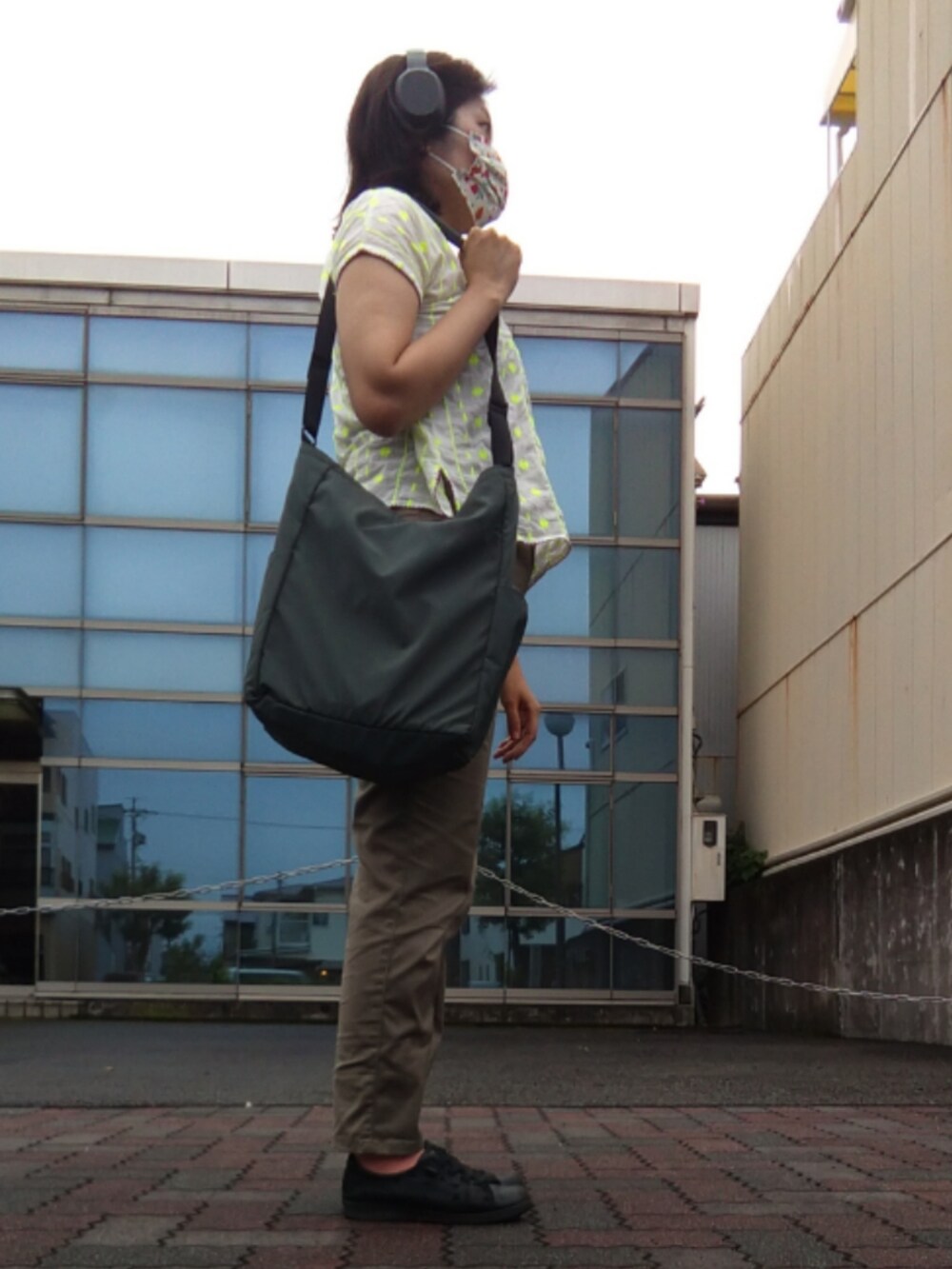 グリーン系のスラックス、ホワイト系のTシャツ/カットソーを着用したレディースの夏コーディネートの2枚目の写真