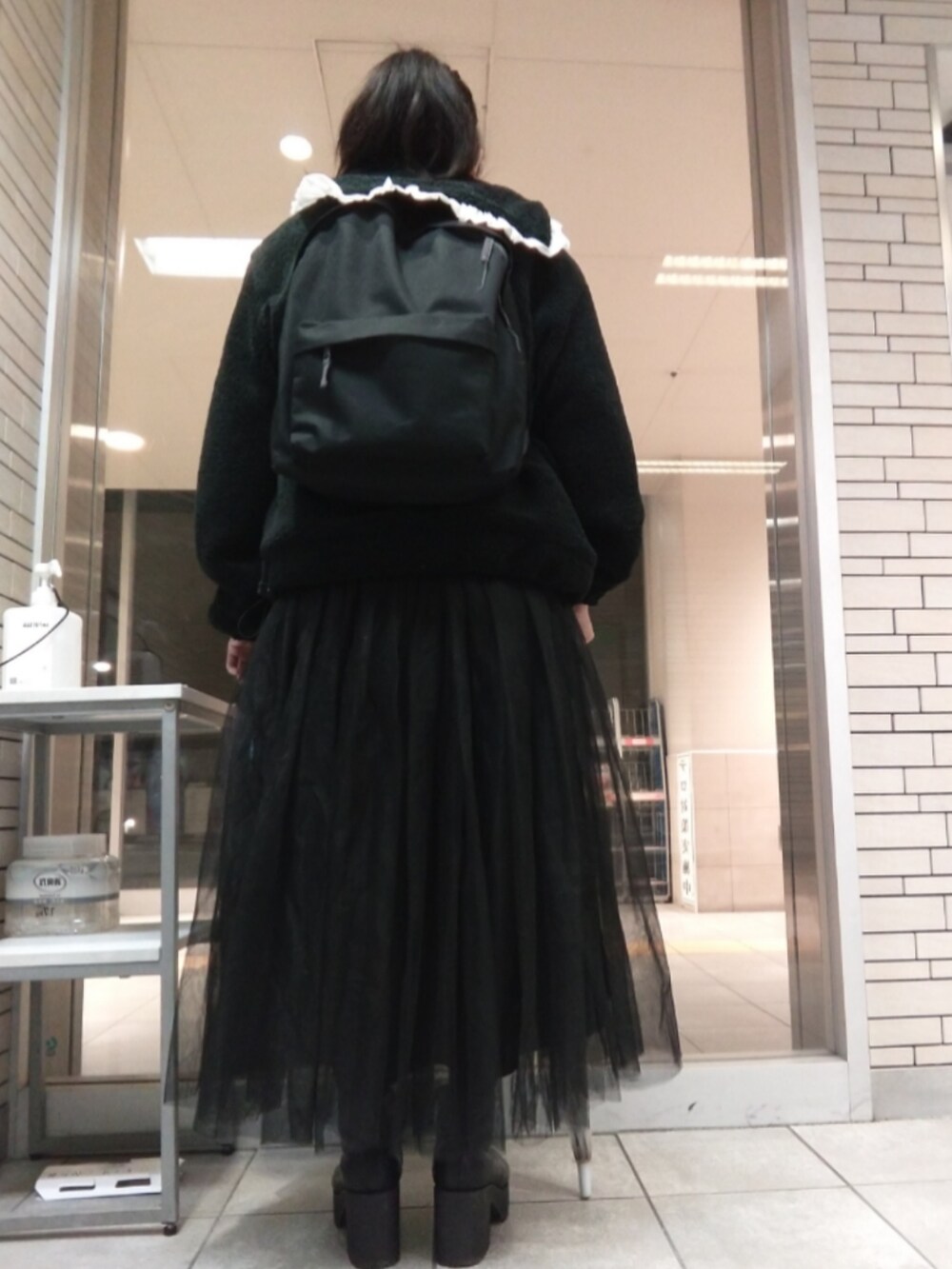 ピンク系のその他アウター、ブラック系のスカート、ブラック系のブーツを着用したレディースの春コーディネートの2枚目の写真
